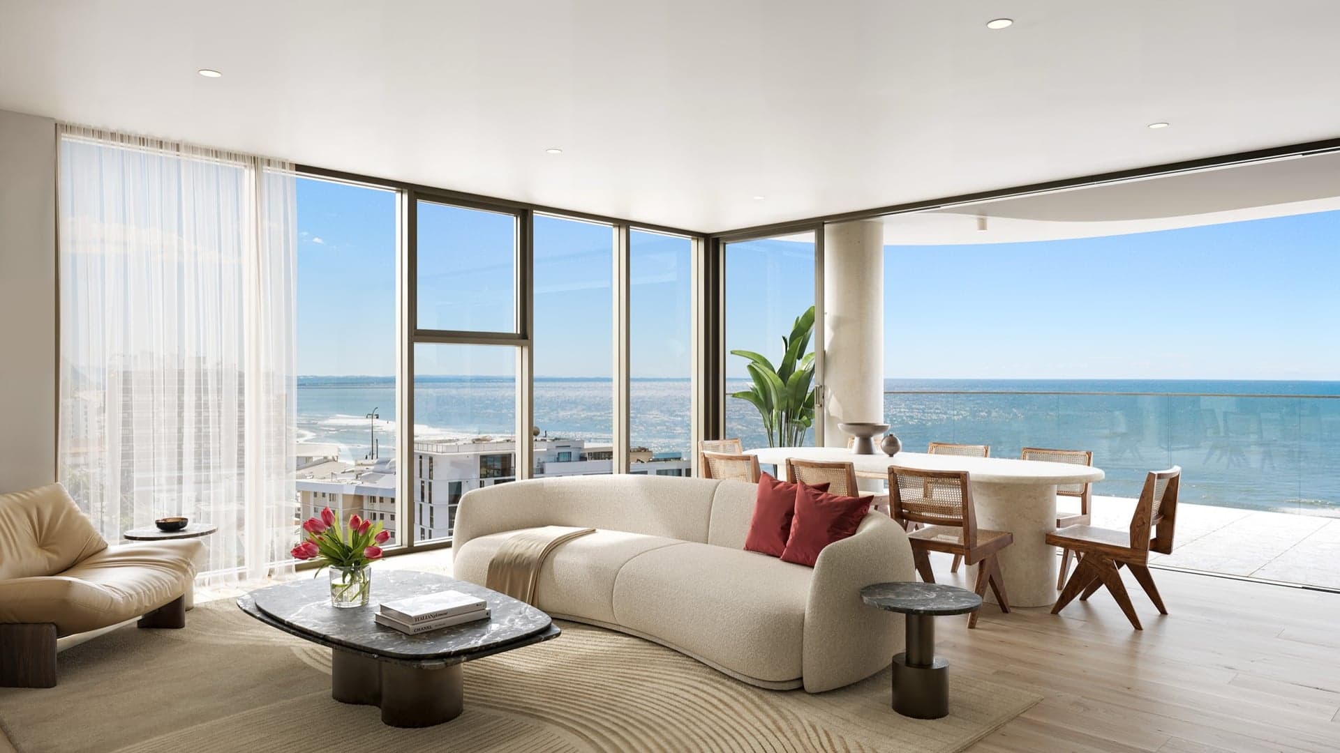 Open-plan living and dining, the ocean beyond the glass